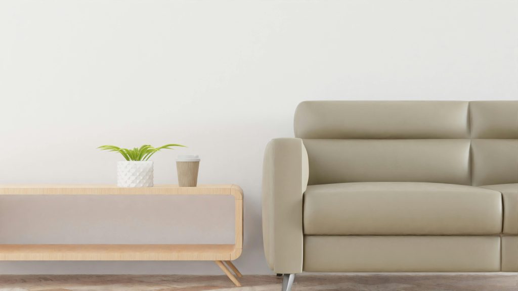 Modern living room with a beige sofa, plant, and coffee cup on a stylish wooden table.